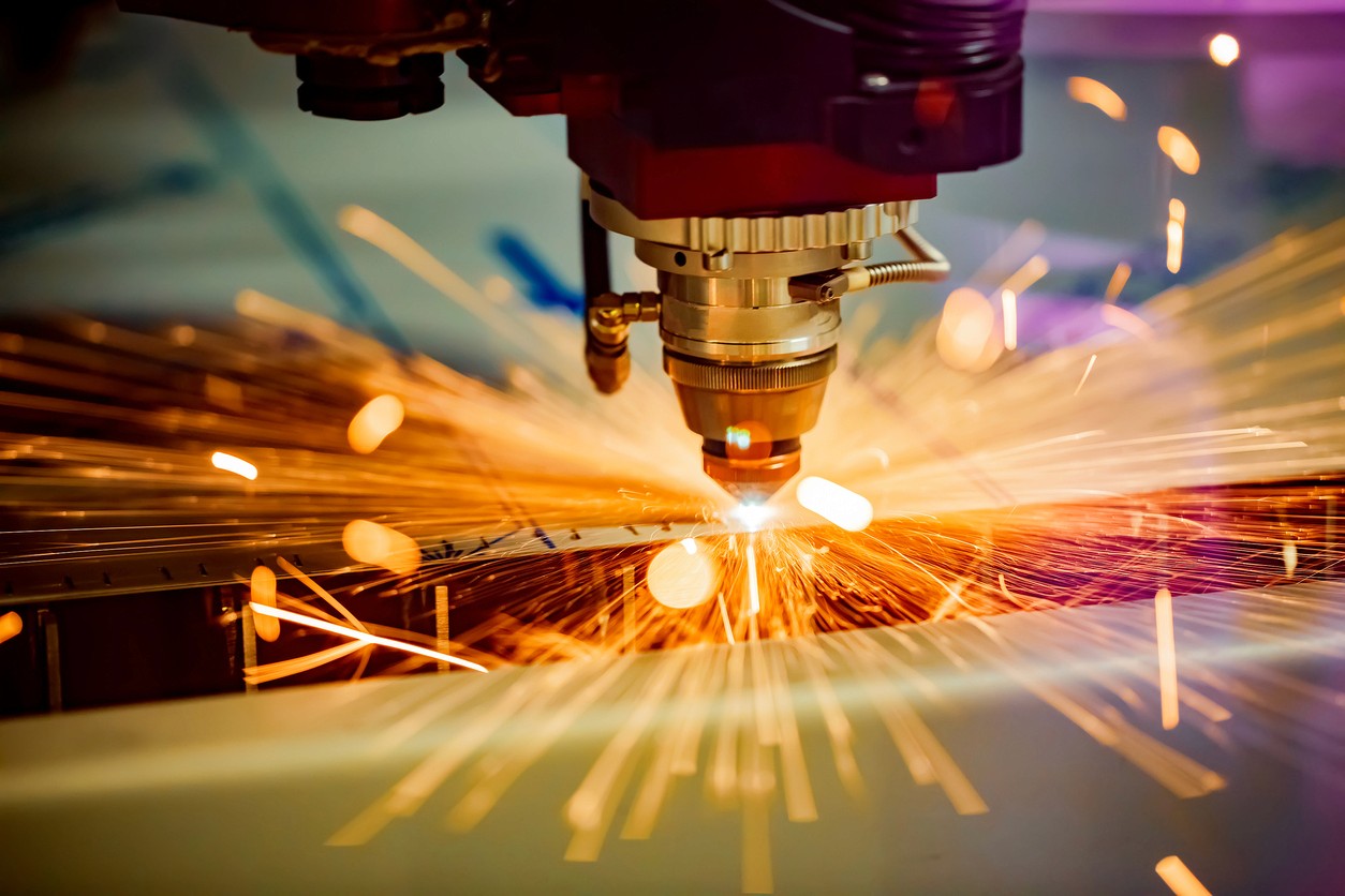 A laser router cuts material with sparks flying