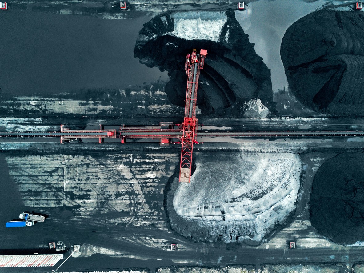 Red crane sitting atop a mining facility